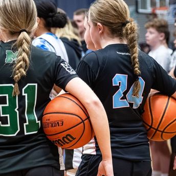 basketball players jumping up under the hoop